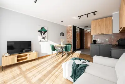 a living room with a couch and a tv and a table at Apartament Nova Płaszów in Kraków