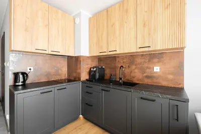 a kitchen with gray cabinets and a sink at Apartament Nova Płaszów in Kraków