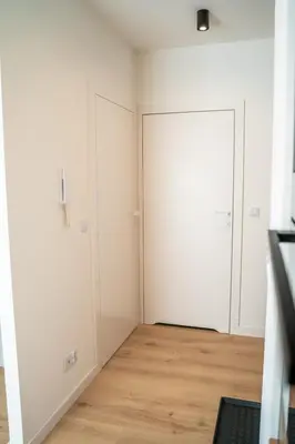 a room with two white doors and a wooden floor at K&M Apartments Tauron Arena, Lema in Kraków