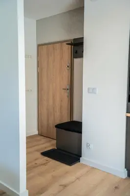 an empty room with a door and a wooden floor at K&M Apartments Tauron Arena, Lema in Kraków
