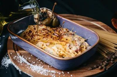 a casserole dish of food on a wooden table at Hotel - Restauracja Koral in Wieliczka