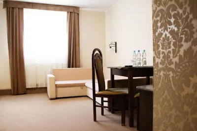 a hotel room with a table and a living room at Hotel - Restauracja Koral in Wieliczka