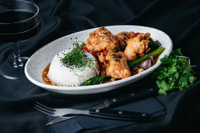a plate of food with rice and vegetables and a glass of wine at Hotel - Restauracja Koral in Wieliczka