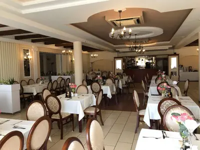 a dining room with white tables and chairs at Hotel - Restauracja Koral in Wieliczka
