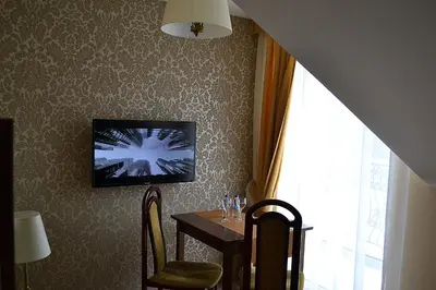 a dining room with a table and a tv on the wall at Hotel - Restauracja Koral in Wieliczka