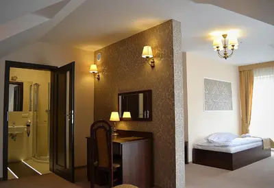 a room with a bathroom with a bed and a mirror at Hotel - Restauracja Koral in Wieliczka