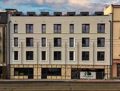 a white building with windows on a city street at Apartment Premium with Air Conditioning, city heart in Cracow in Kraków
