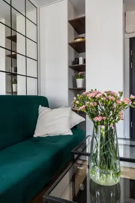 a living room with a green couch and a vase of flowers at Apartment Premium with Air Conditioning, city heart in Cracow in Kraków