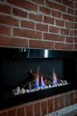 a brick wall with a fire in a fireplace at Apartment Premium with Air Conditioning, city heart in Cracow in Kraków