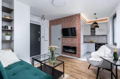 a living room with a green couch and a brick wall at Apartment Premium with Air Conditioning, city heart in Cracow in Kraków