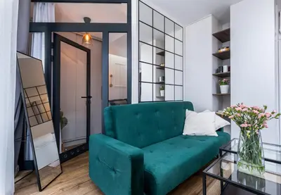 a green couch in a living room with a mirror at Apartment Premium with Air Conditioning, city heart in Cracow in Kraków