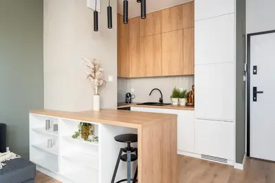 a kitchen with white cabinets and a wooden counter top at Malila Premium Apartments Cracow Rakowicka 437 in Kraków