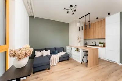 a living room with a blue couch and a kitchen at Malila Premium Apartments Cracow Rakowicka 437 in Kraków