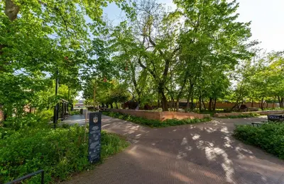 a path in a park with trees and a sign at Malila Premium Apartments Cracow Rakowicka 437 in Kraków