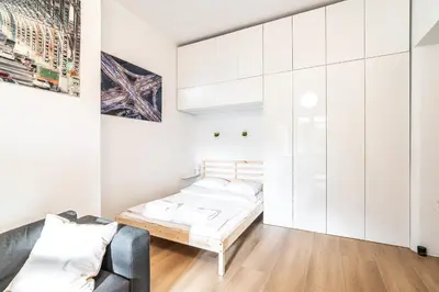 a white room with a bed and a couch at ShortStayPoland Józefitów C4 in Kraków