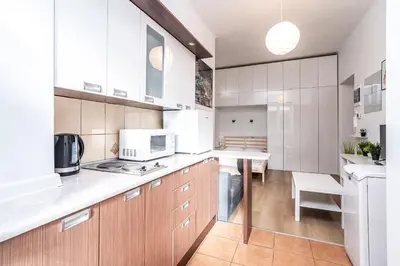 a kitchen with white cabinets and a counter top at ShortStayPoland Józefitów C4 in Kraków