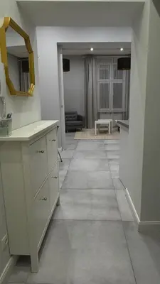 a kitchen with white cabinets and a tile floor at B37 Kazimierz Apartment in Kraków