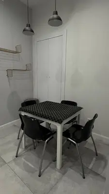 a table with four chairs in a white room at B37 Kazimierz Apartment in Kraków