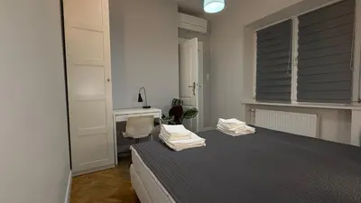 a bedroom with a bed with a chair and a desk at B37 Kazimierz Apartment in Kraków
