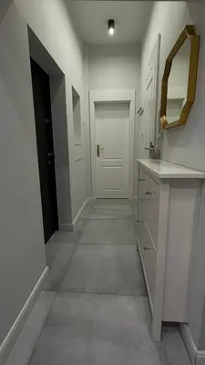 a hallway with a sink and a mirror and a door at B37 Kazimierz Apartment in Kraków