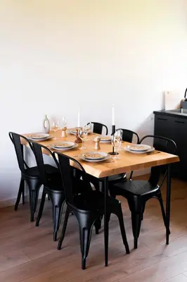a wooden table with chairs and wine glasses on it at Łyse Stodoły in Mordarka