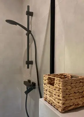 a shower with a basket next to a shower head at Łyse Stodoły in Mordarka