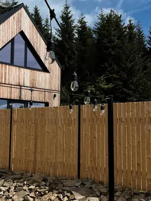 a wooden fence with lights on top of it at Łyse Stodoły in Mordarka