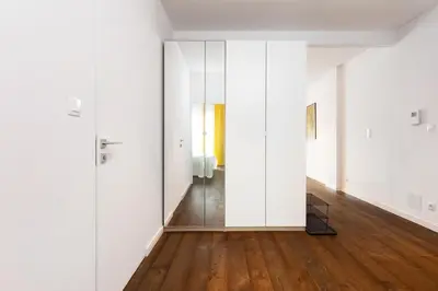 an empty room with white walls and wooden floors at NEARTOpl Rakowicka Family apartments in Kraków