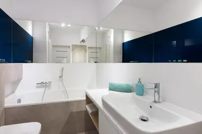 a white bathroom with a sink and a tub at NEARTOpl Rakowicka Family apartments in Kraków