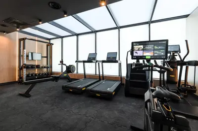 a gym with treadmills and machines and windows at Wings Plaza in Kraków