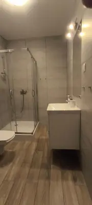 a bathroom with a shower and a sink and a toilet at Apartment Orlińskiego in Kraków