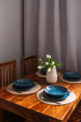 a wooden table with blue plates and a vase of flowers at Loretas Roses Apartment Krakow Old Town in Kraków