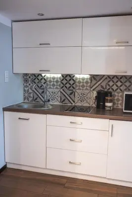 a kitchen with white cabinets and a sink at Loretas Roses Apartment Krakow Old Town in Kraków