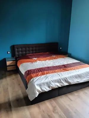 a bed in a room with a blue wall at Apartament Szóstka nad Sołą in Czaniec