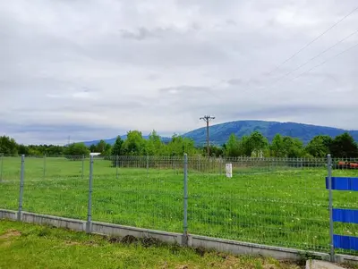 a fence in a field with mountains in the background at Apartament Szóstka nad Sołą in Czaniec