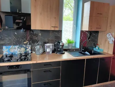 a kitchen with a counter with a stove and a sink at Apartament Szóstka nad Sołą in Czaniec