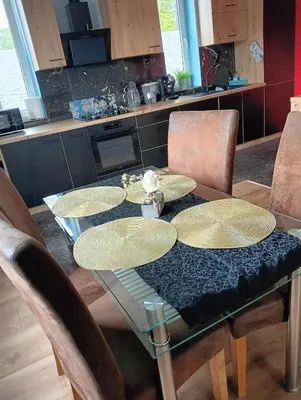 a dining room table with chairs and a table with plates on it at Apartament Szóstka nad Sołą in Czaniec
