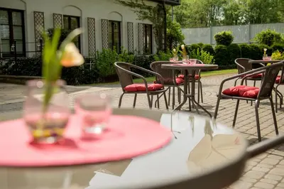 a group of tables and chairs with glasses on them at Hotel Dwór Kościuszko in Kraków