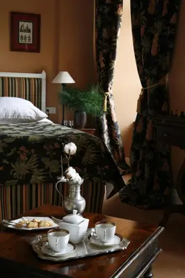 a room with a bed and a table with cups and saucers at Hotel Dwór Kościuszko in Kraków
