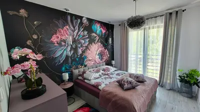 a bedroom with a flower mural on the wall at Domek Liliowe Marzenie in Chrzanów