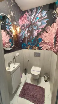a bathroom with a toilet and a flower mural on the wall at Domek Liliowe Marzenie in Chrzanów