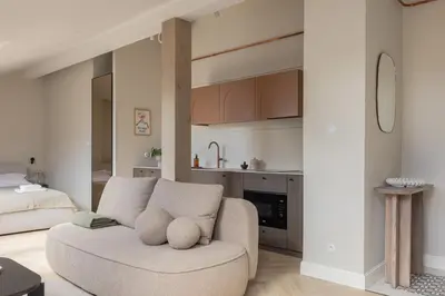 a living room with a couch and a kitchen at Venus Apartment in Kraków
