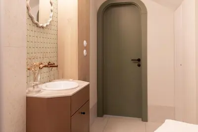 a bathroom with a sink and a green door at Venus Apartment in Kraków