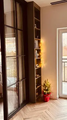 a room with a christmas tree and a book shelf at Nowoczesny apartament w Makowie Podhalańskim in Maków Podhalański