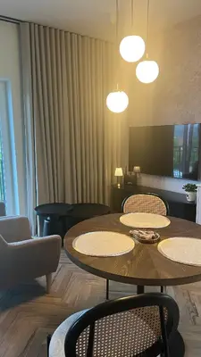 a living room with a table and chairs and lights at Nowoczesny apartament w Makowie Podhalańskim in Maków Podhalański