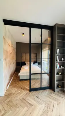 a bedroom with a bed and a glass wall at Nowoczesny apartament w Makowie Podhalańskim in Maków Podhalański