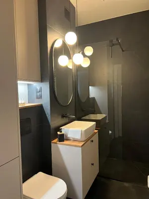 a bathroom with a toilet and a sink and a mirror at Nowoczesny apartament w Makowie Podhalańskim in Maków Podhalański