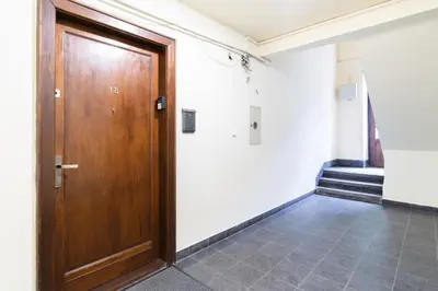 a wooden door in a room with a tile floor at Park Krakowski Homely Studio with Garden by BookingHost in Kraków