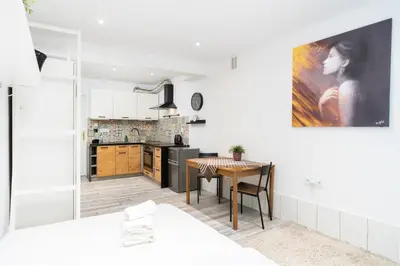 a kitchen and dining room with a table in a room at Park Krakowski Homely Studio with Garden by BookingHost in Kraków