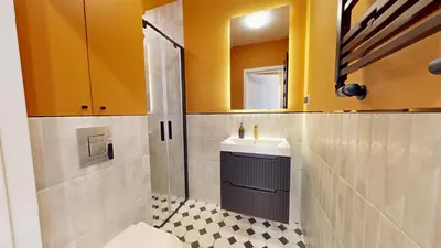 a bathroom with a sink and a toilet and a mirror at Apartamenty na Pana Tadeusza in Kraków